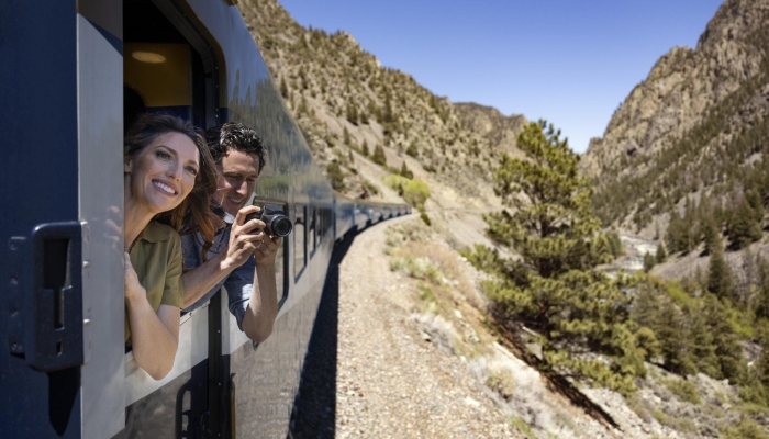 Guests taking a photo from the outdoor viewing platform onboard Rocky Mountaineer
