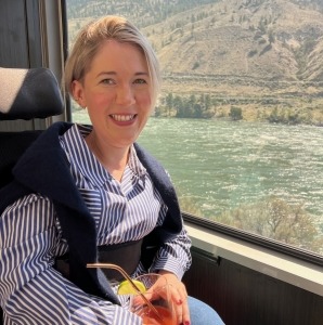 A woman sitting in a wheelchair beside a window with a river outside while onboard the Rocky Mountaineer train