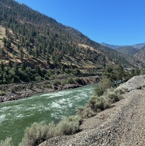 A glacial river alongside train tracks.
