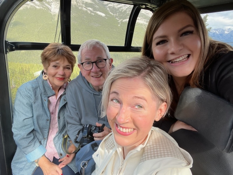 A family smiling at the camera while on the Banff Gondola.